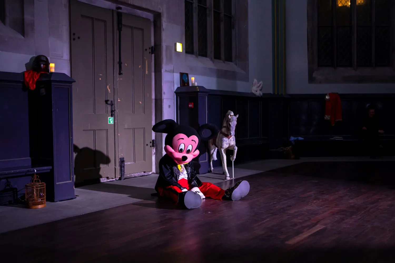 Micky sitzt neben einer lebensgroßen Pferdefigur im Kirchenraum.